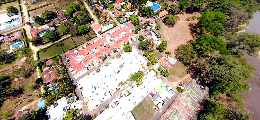 Vista aérea de un condominio residencial con piscinas y zonas verdes en Melgar, Tolima